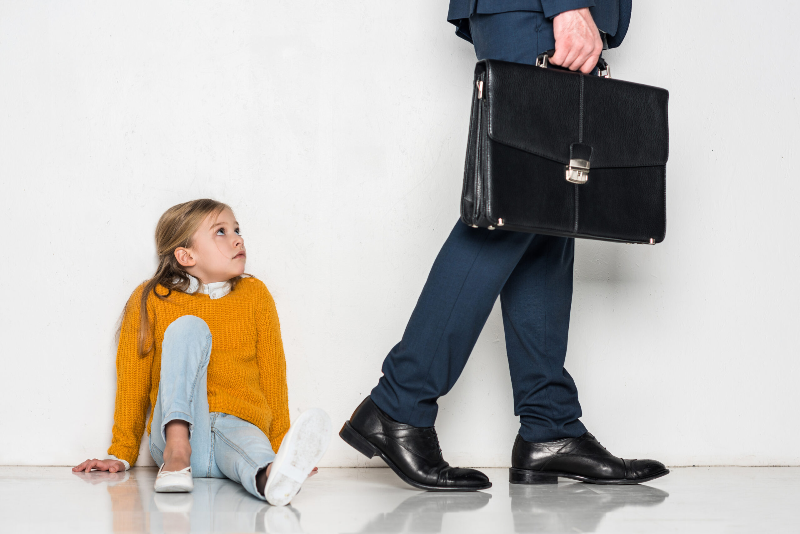 upset daughter looking at father in business suit walking away isolated on grey