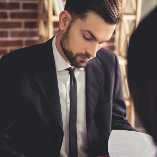 Handsome employer in suit is conducting a job interview while sitting in his office